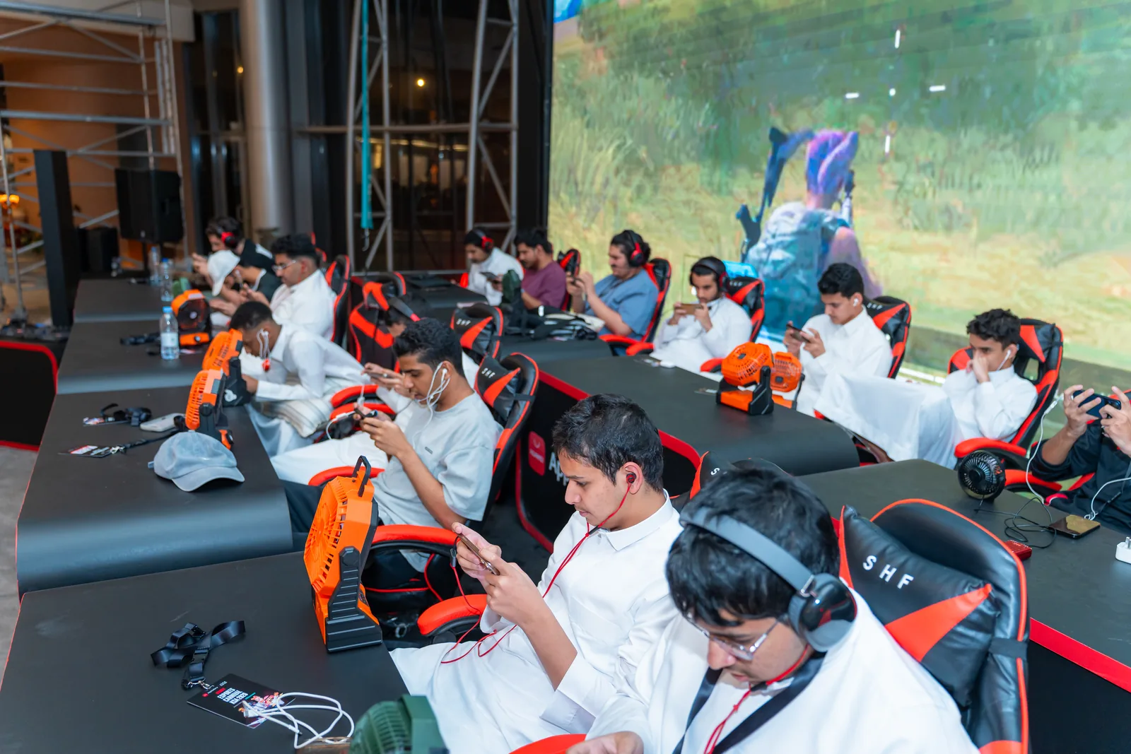 Rows of players competing on mobile devices at the event stage
